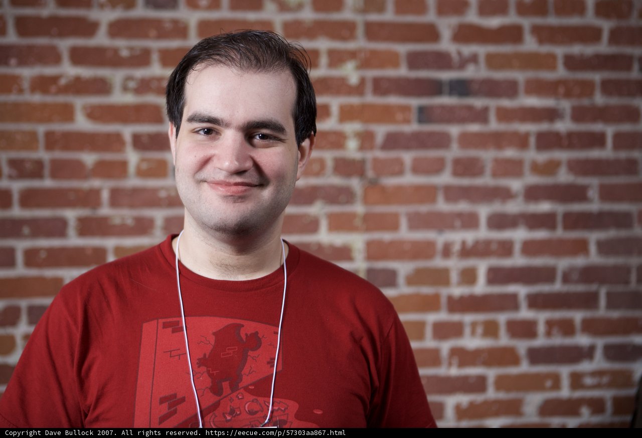 Happy Dan Kaminsky posing in front of brick wall