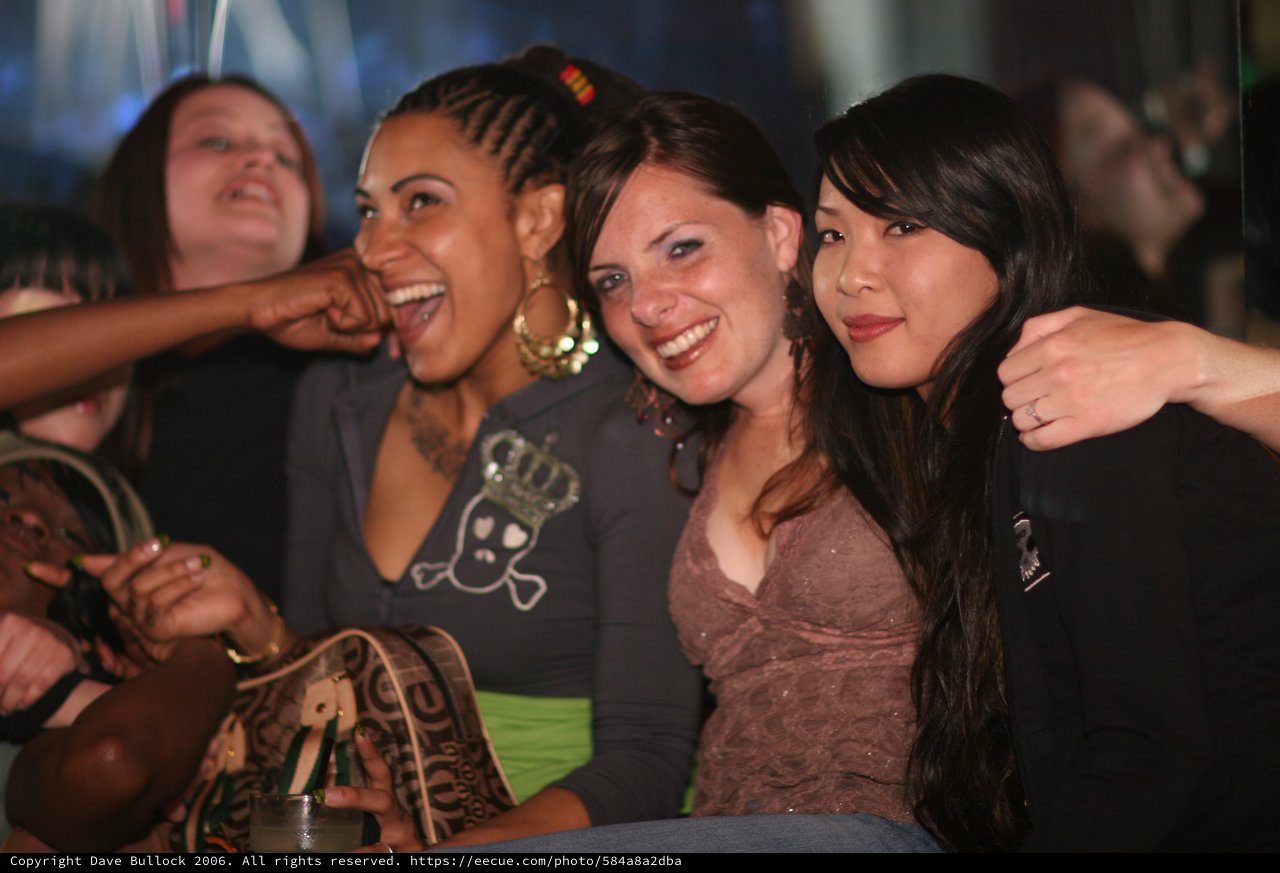 Three Friends Laughing Together at Nightclub Party