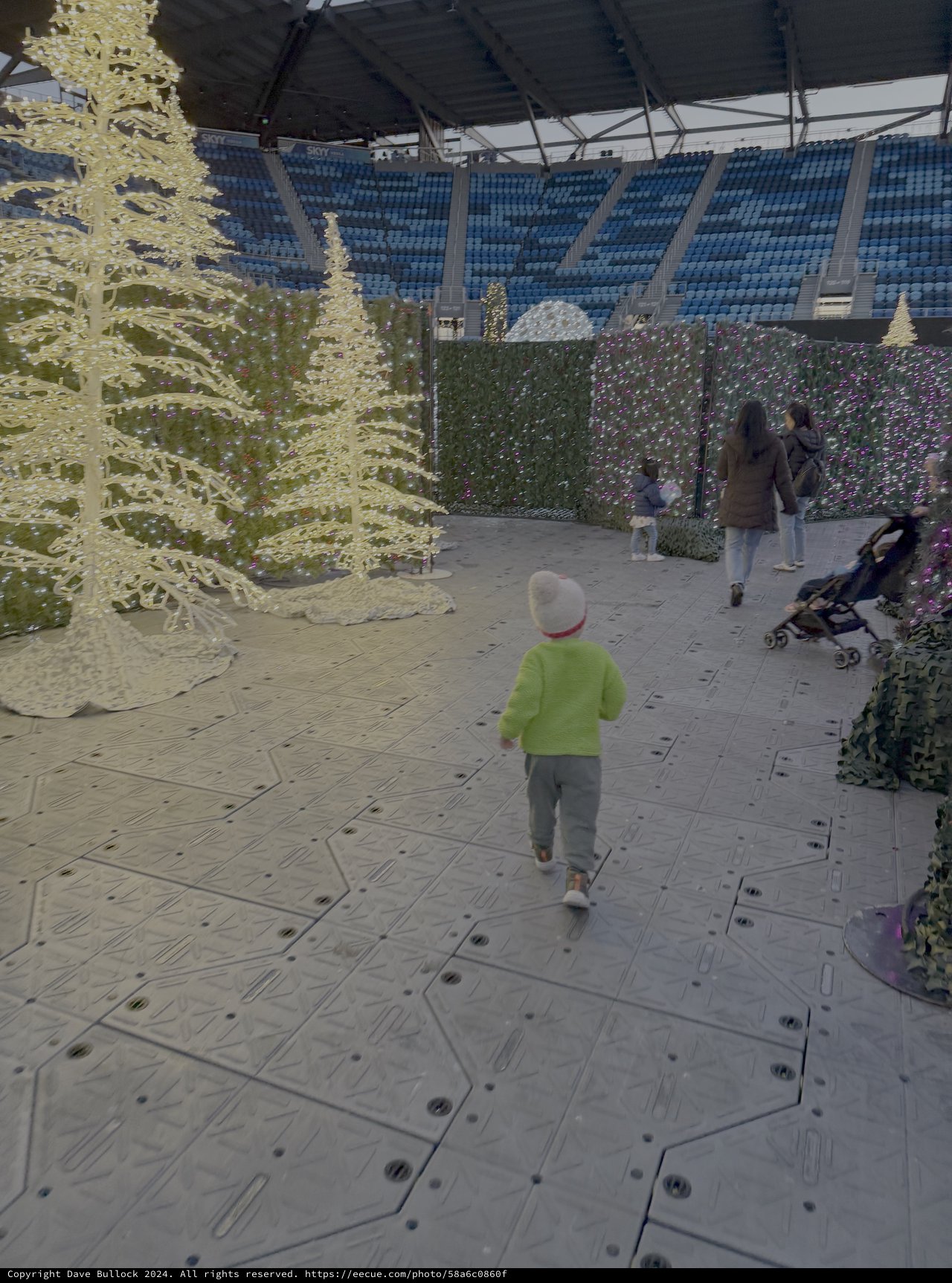 Child Exploring Christmas Light Display in Stadium