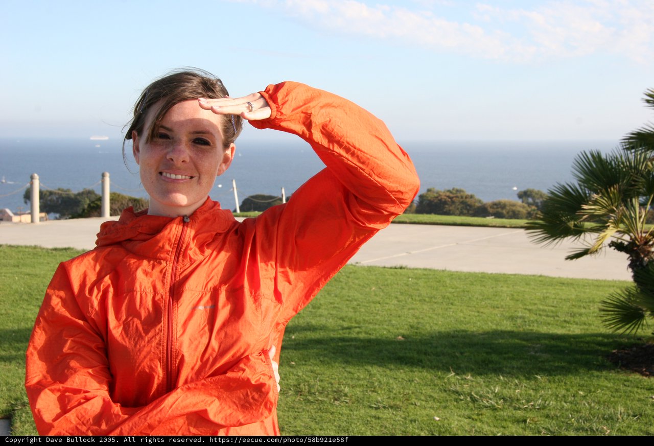Young Woman Saluting by the Pacific Ocean