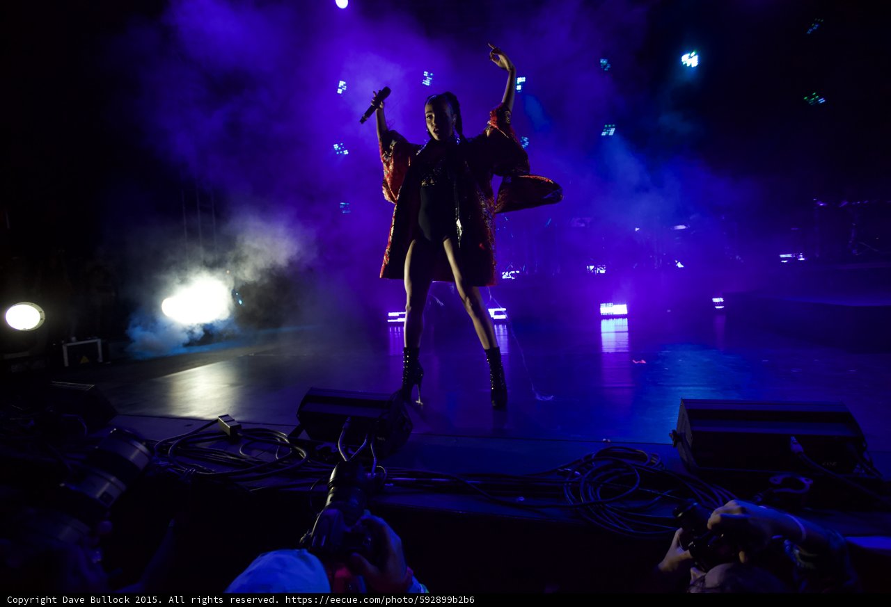 FKA twigs Incredible Full Body Silhouette Arm Raised Microphone Leg Kicked Back Kimono Flowing Red Brocade Black Bodysuit Boots Spotlight Photographers Haze