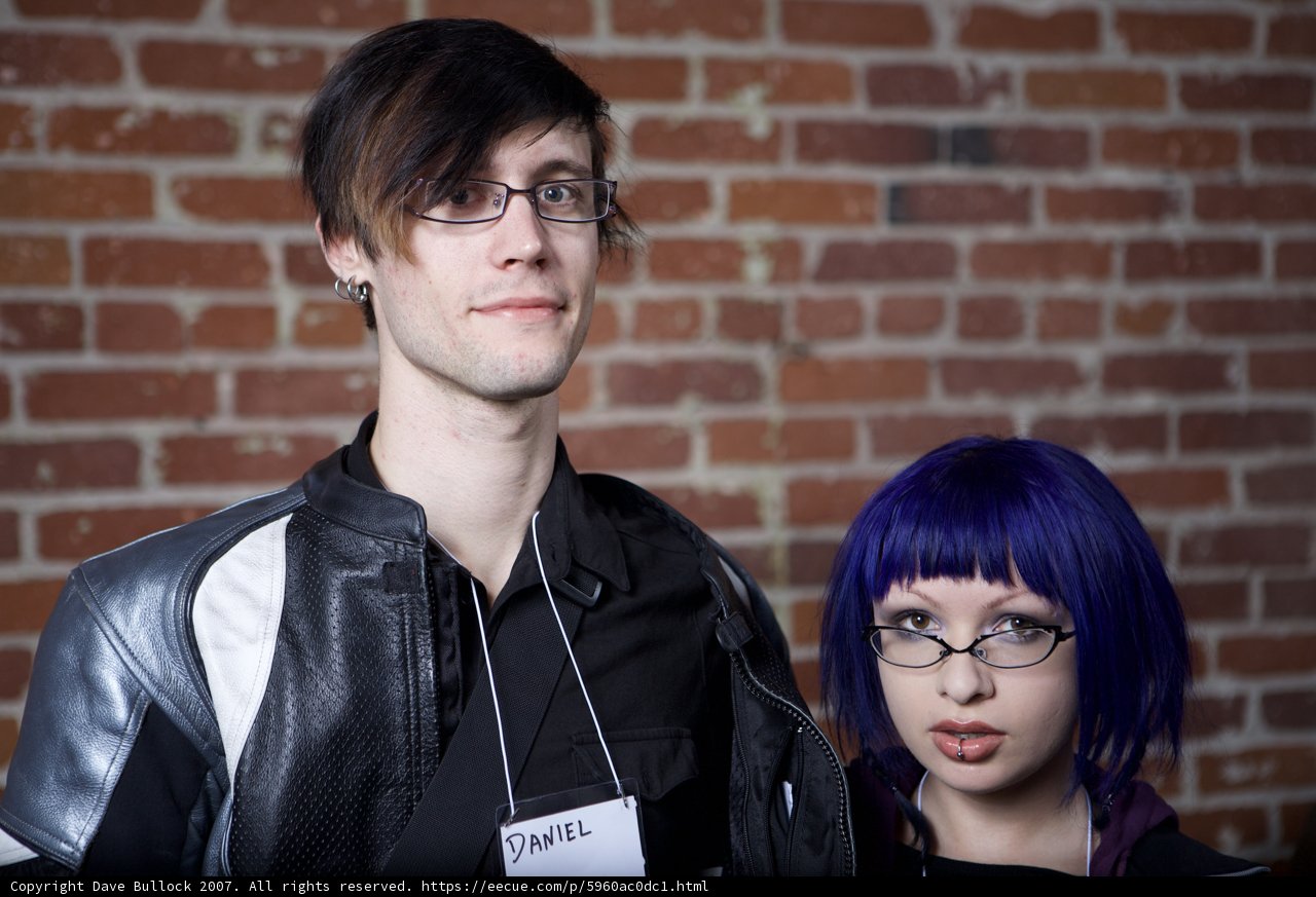 Purple-haired Duo Poses on Brick Building