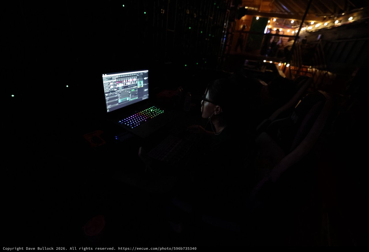 DJ Operator Controls Lights in Dark Festival Booth