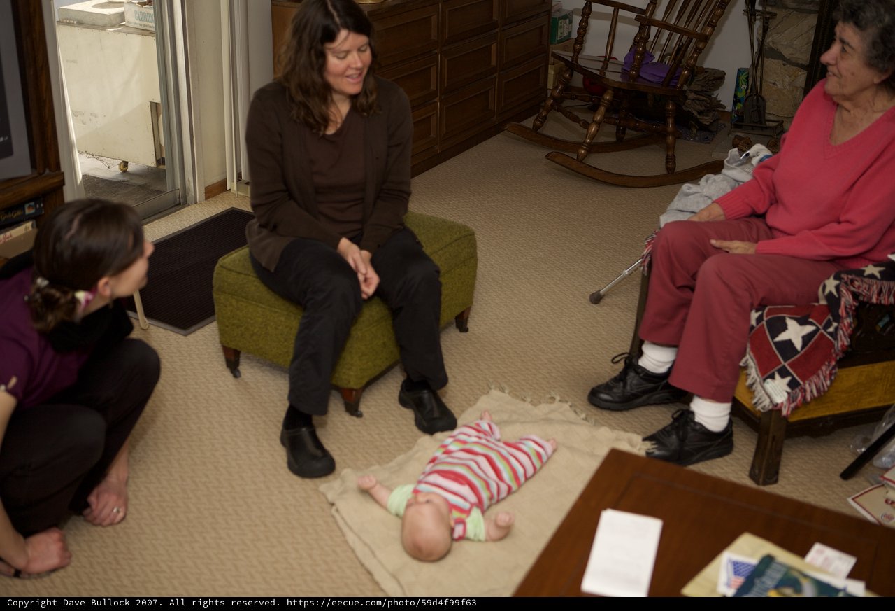 Three Generations Gathered Around a Newborn Baby