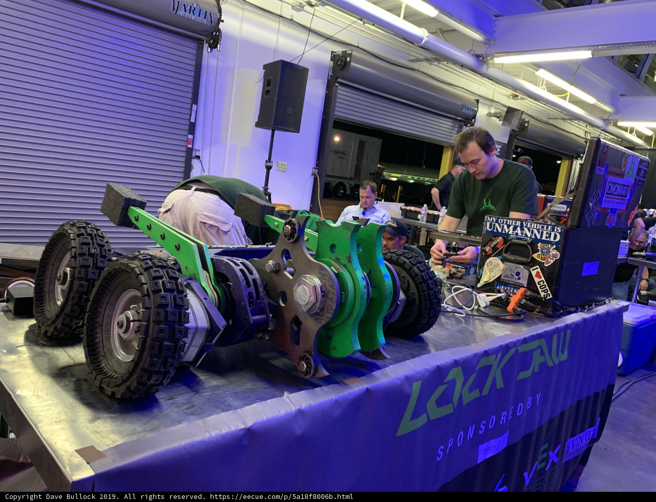 Building a Futuristic Machine: A Man Works on a Robot at a Convention