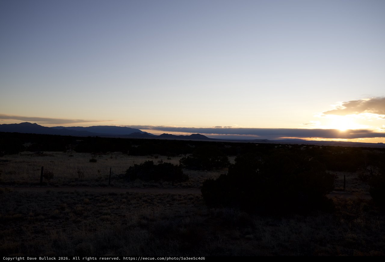 Sunset Over Mountain Silhouettes in Desert Landscape