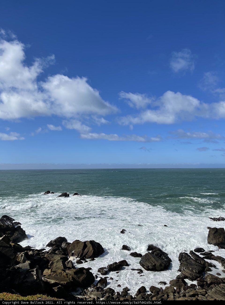 A Breathtaking View of the Ocean and Rocks from a Promontory