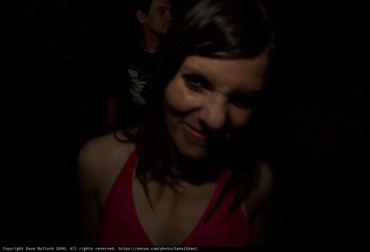 Young Woman Smiling in Dimly Lit Venue