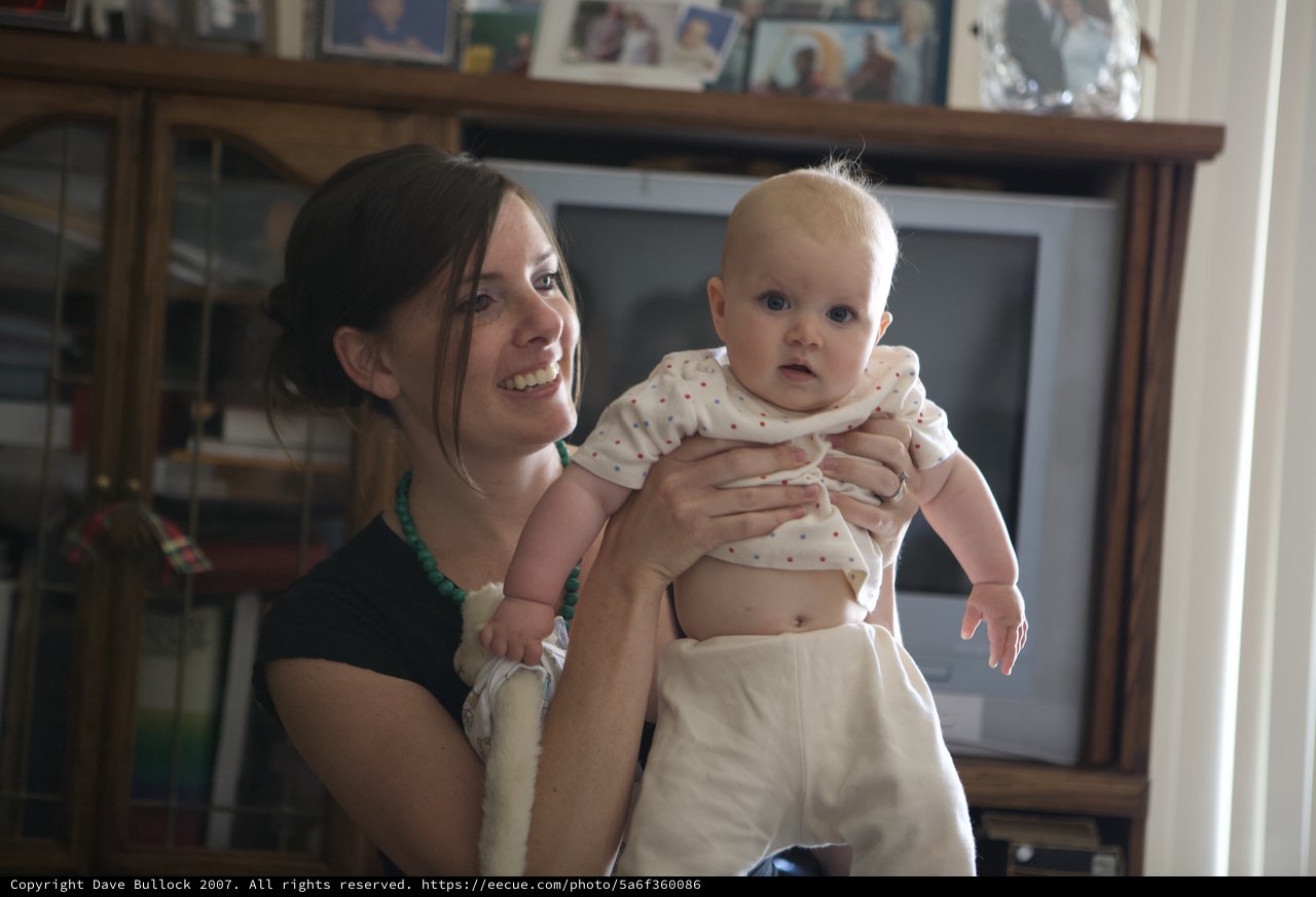 Mother Holding Curious Baby in Cozy Living Room
