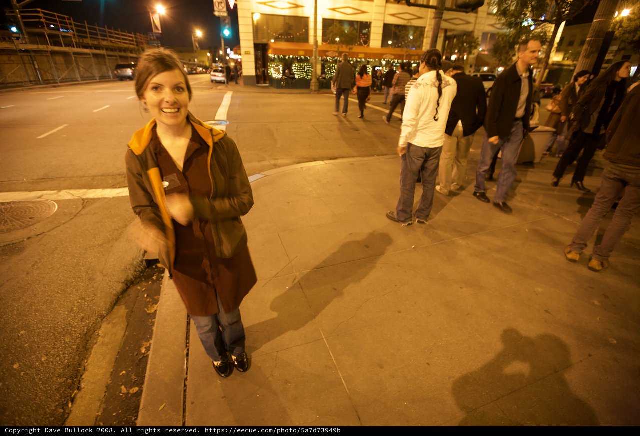 Smiling Woman on Bustling City Street at Night