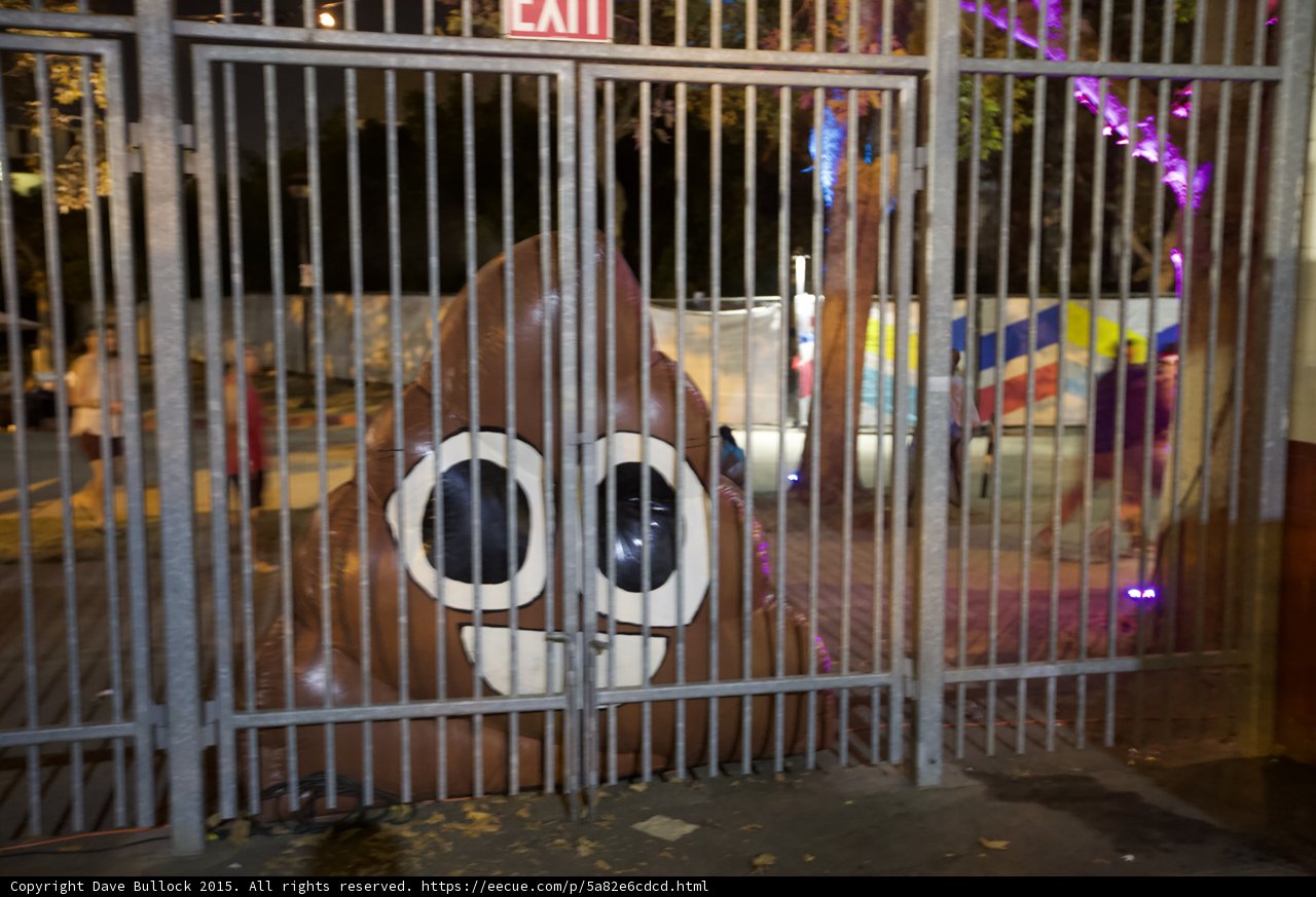 FYF Fest Deflated Poop Emoji Inflatable Behind Fence Exit Sign Purple Lights Art Installation