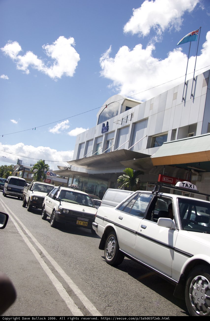 Clouds overhead as 8 cars line the street
