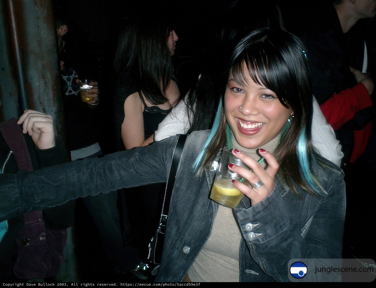 Blue-haired Woman Sipping a Drink at the Club