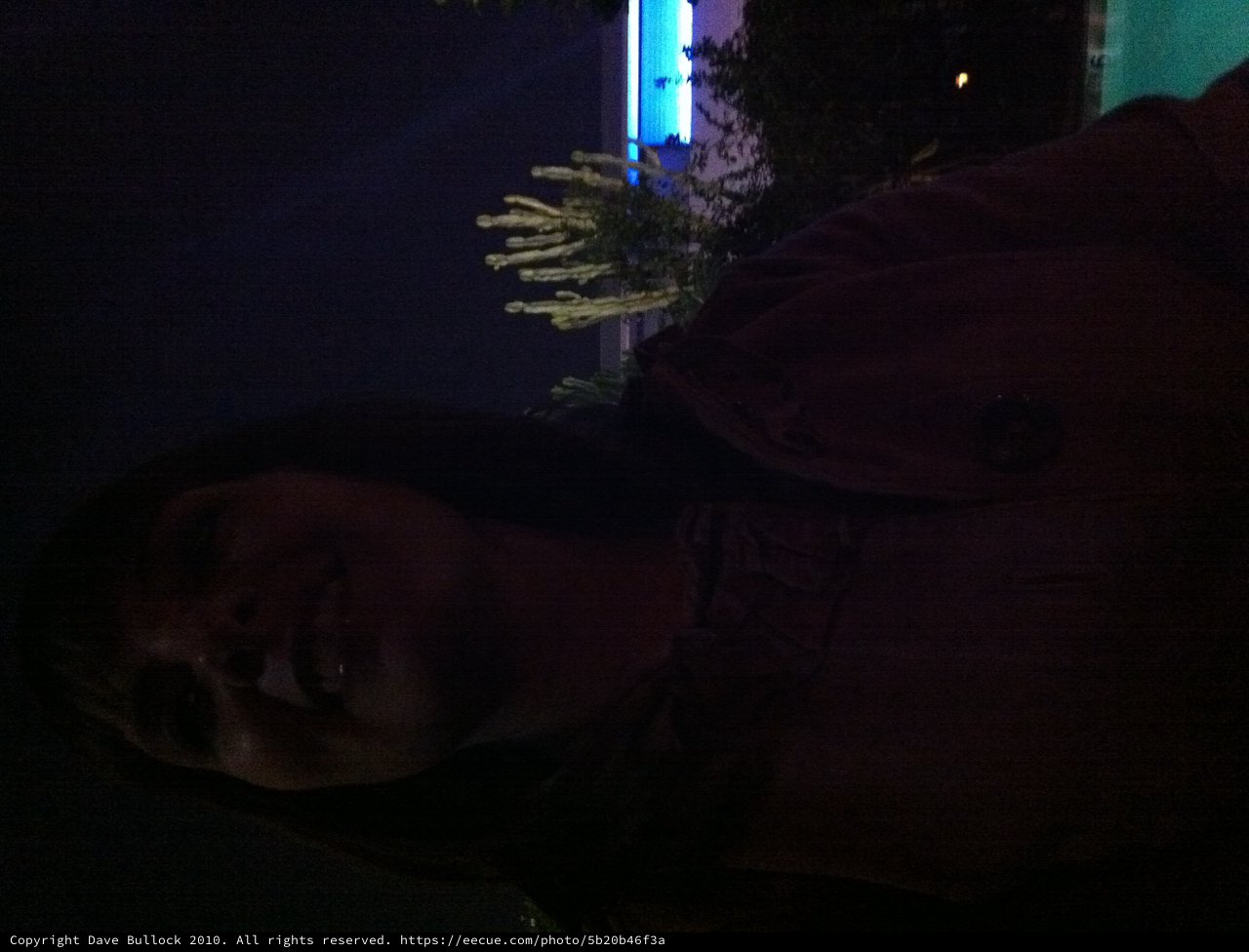 Woman Gazing Upward by Illuminated Pool at Night