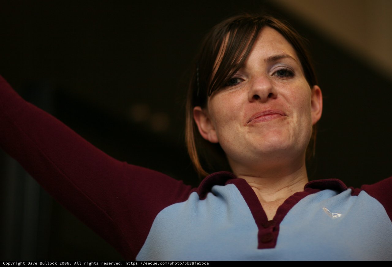 Woman in Claret and Blue Raises Her Arms