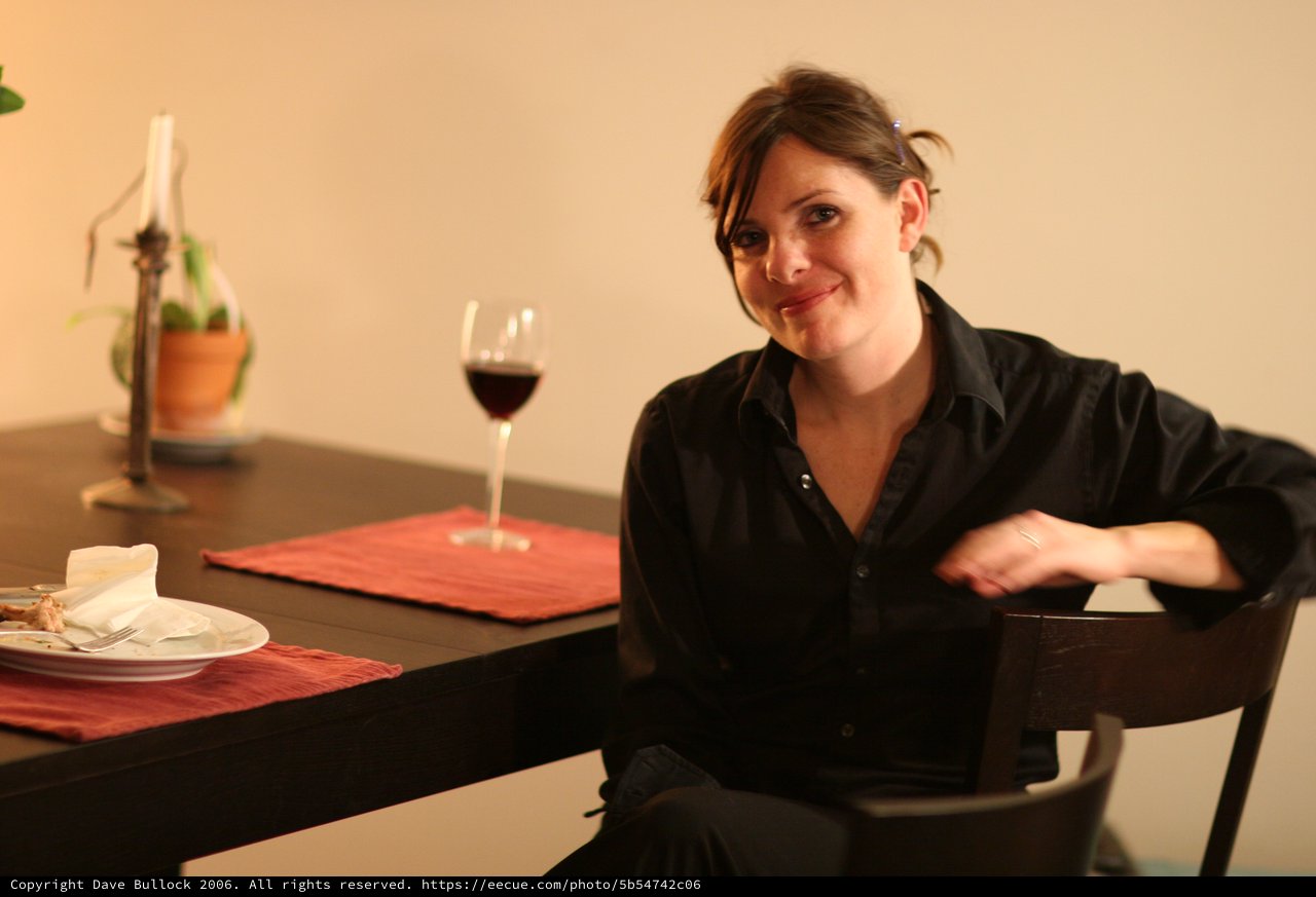 Woman Relaxing at Dinner Table with Red Wine