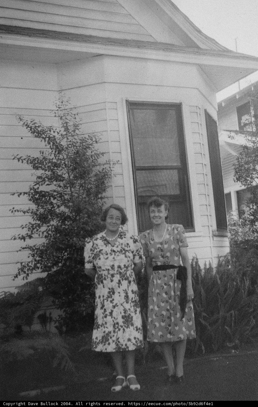 Two Women Posing in Front of a Rural Home