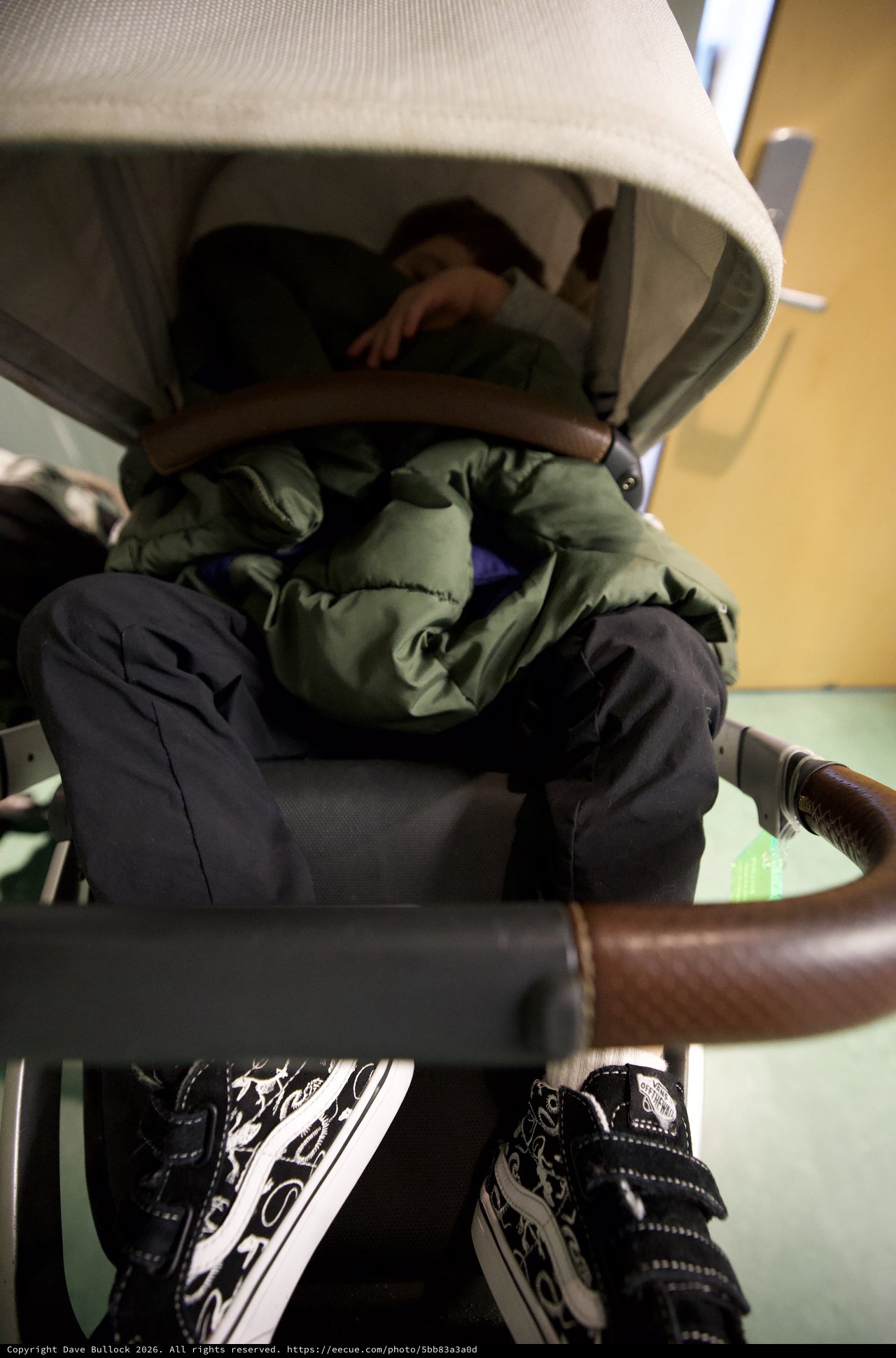 Child in Stroller with Green Jacket and Patterned Shoes