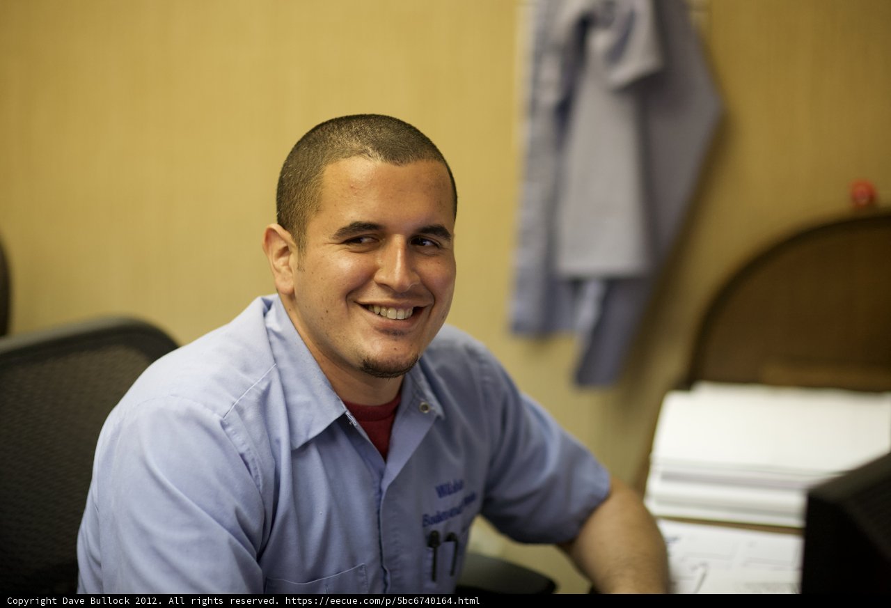 Smiling Man in Blue Shirt at Work Desk