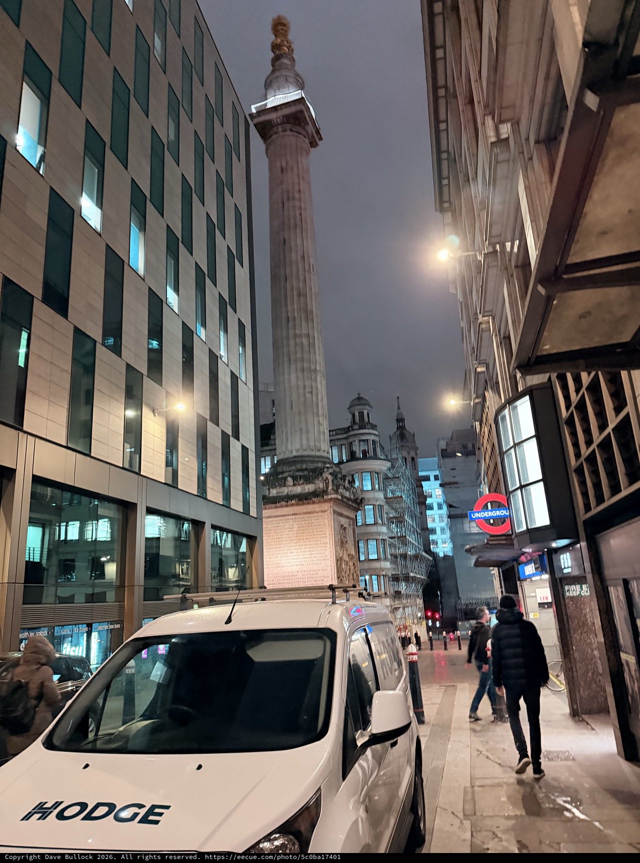 Monument Column Towers Over Modern London Street at Night