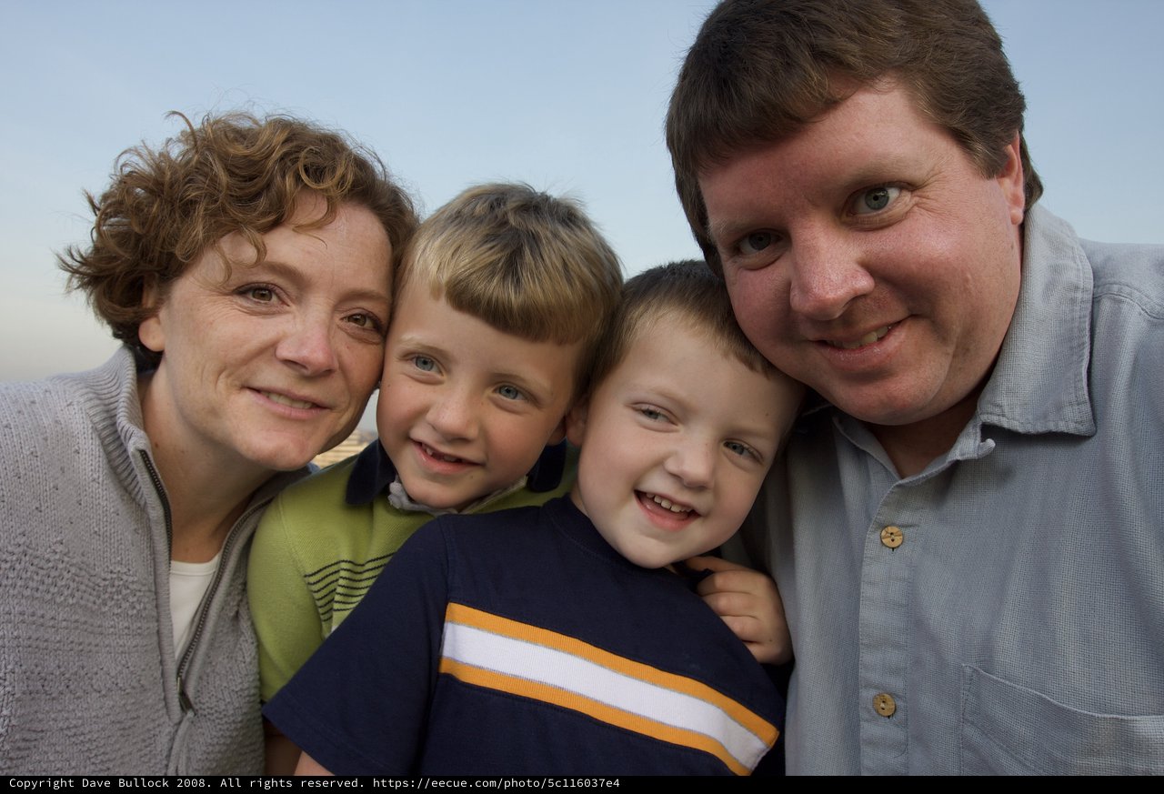 Happy Family of Four Poses Together Outdoors