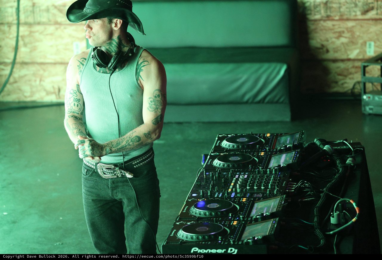Tattooed DJ Stands Before Pioneer Setup at Wobbleland