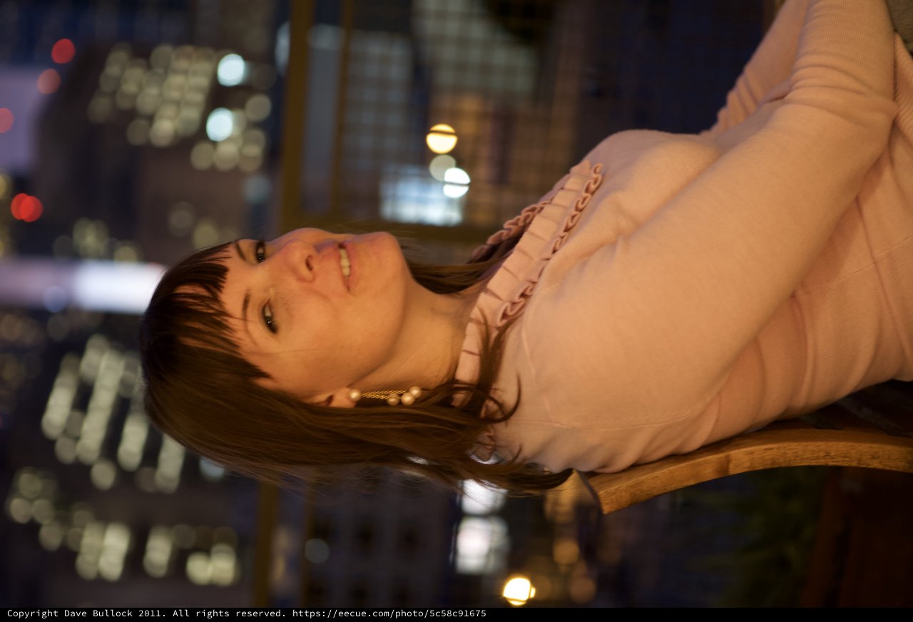 Penelope Gazes Upward Against City Night Lights