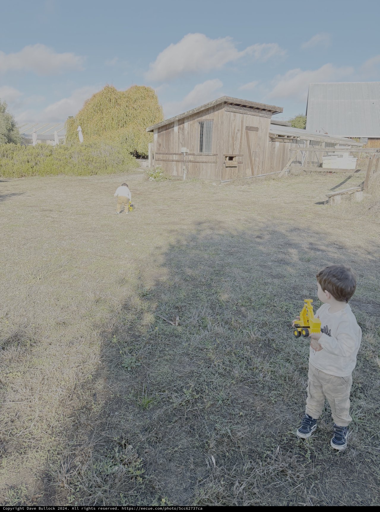Child Playing with Toy Truck in Rural Farmyard