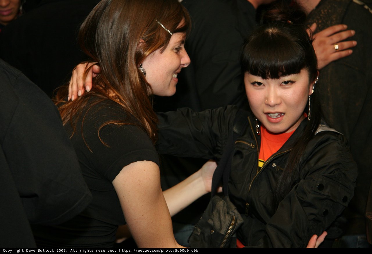 Two Women Share an Animated Moment at Night Event