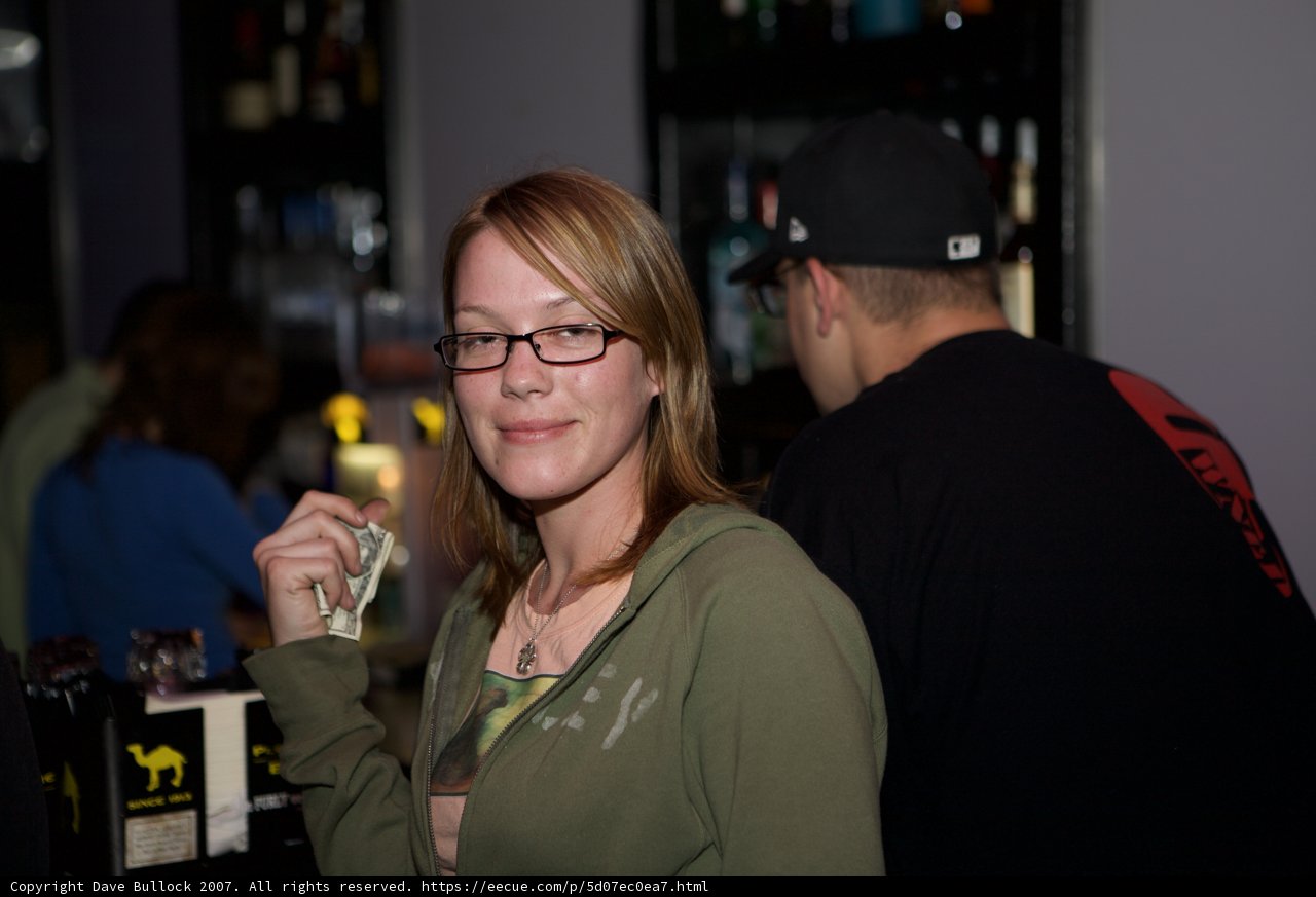 Woman in a Green Jacket Standing in Front of a Pub