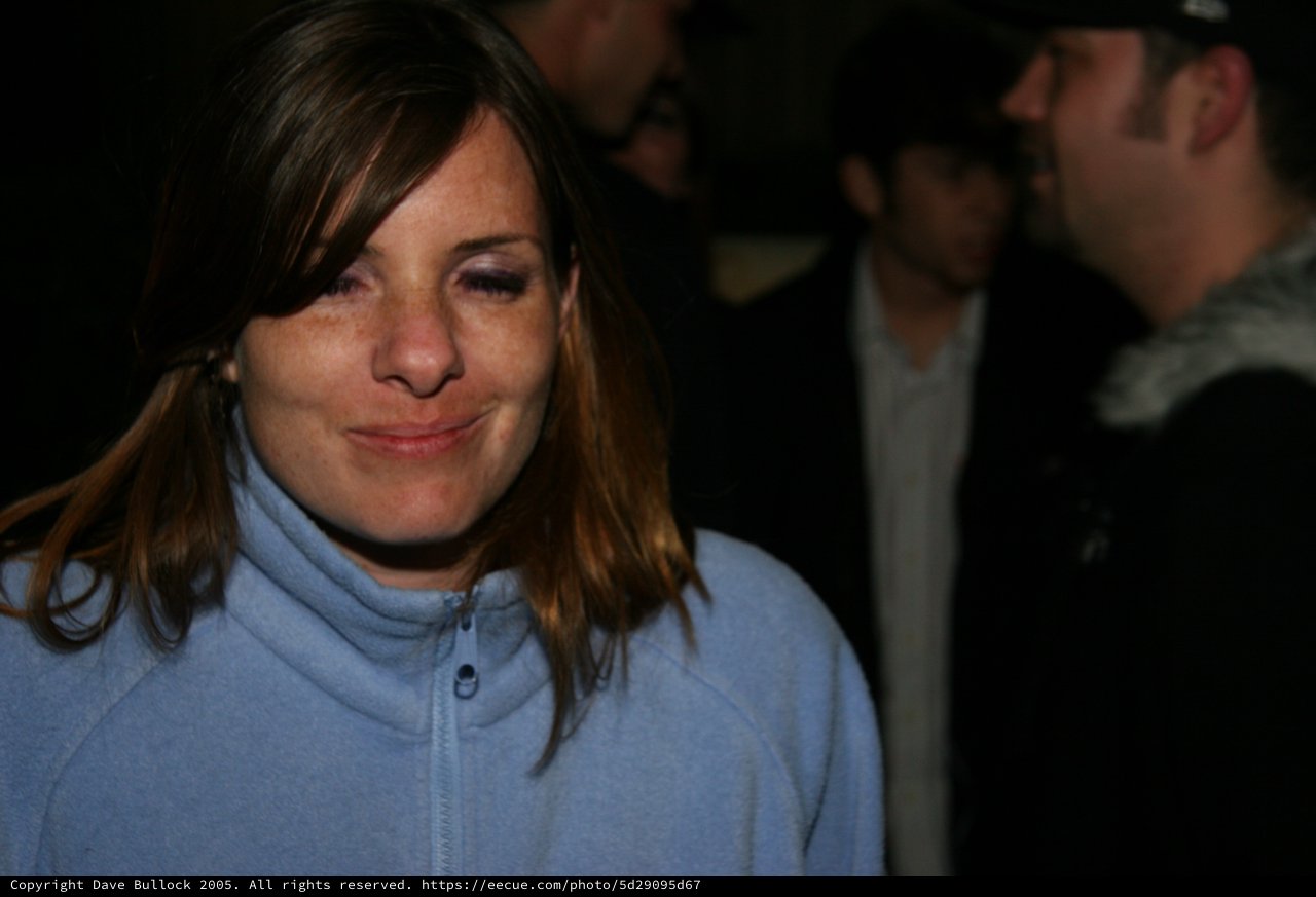 Woman Smiling Candidly at Nighttime Outdoor Gathering
