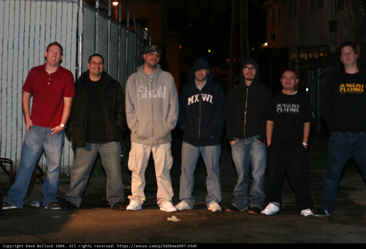 Group of men posing in front of building