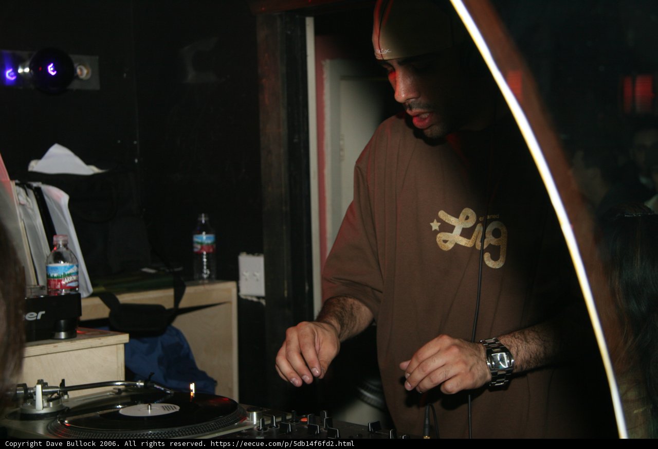 Deejay in Brown Shirt Spins Music on Turntable