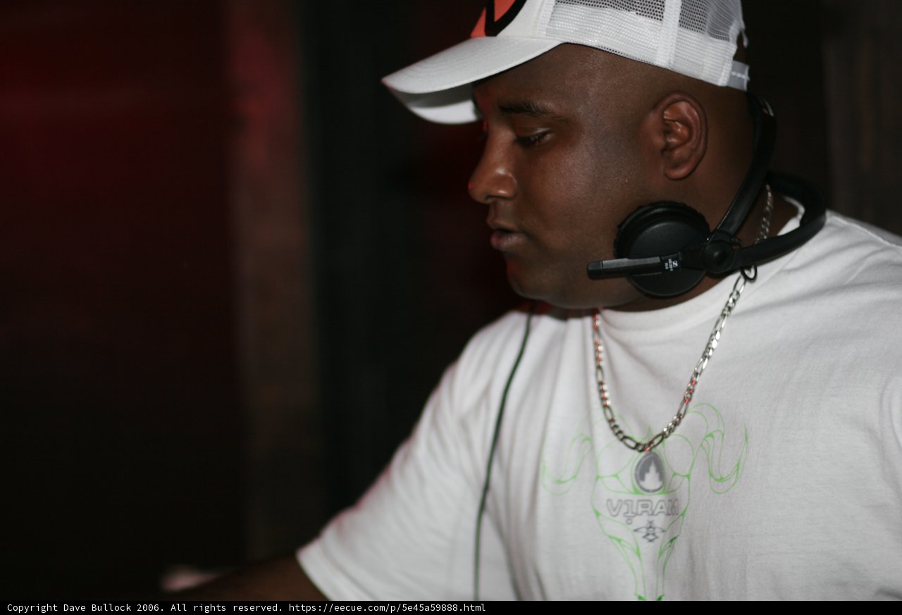 Man in White Shirt Wearing Baseball Cap and Headphones