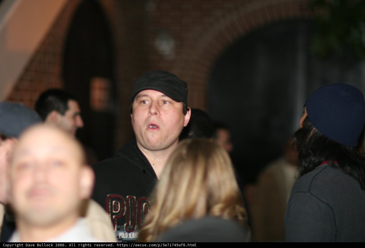 Man with a Black Baseball Cap in a Crowded Pub
