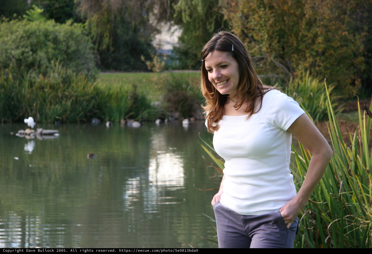 Smiling Woman by a Tranquil Park Pond