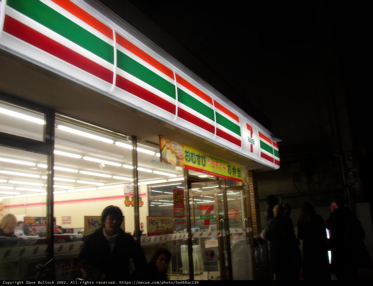 Nighttime Gathering at a Busy Osaka Storefront