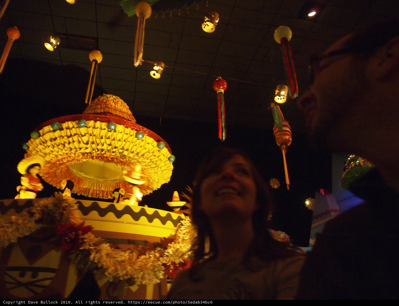 Couple Marvels at Mexican Sombrero Display in Festive Venue