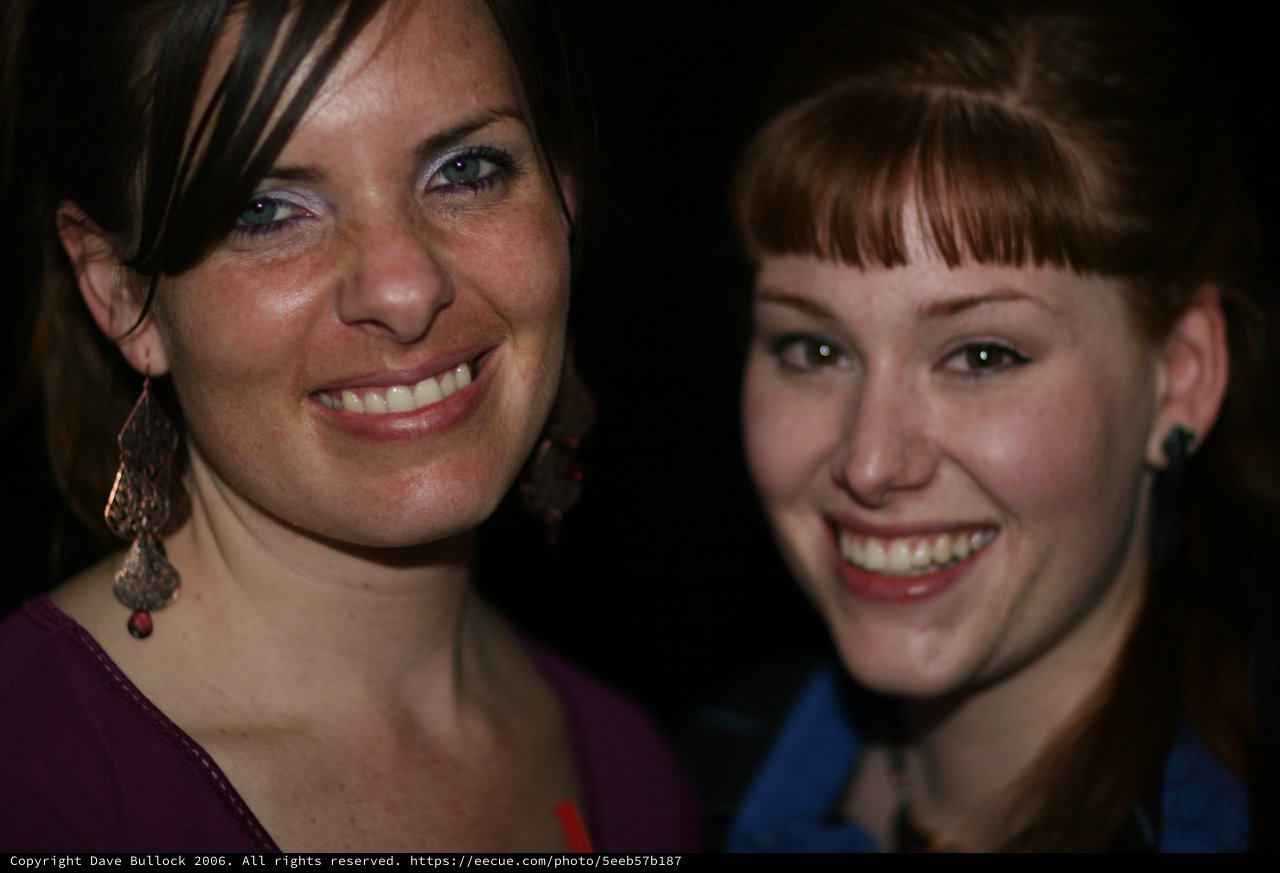 Two Smiling Women at a Nighttime Social Event