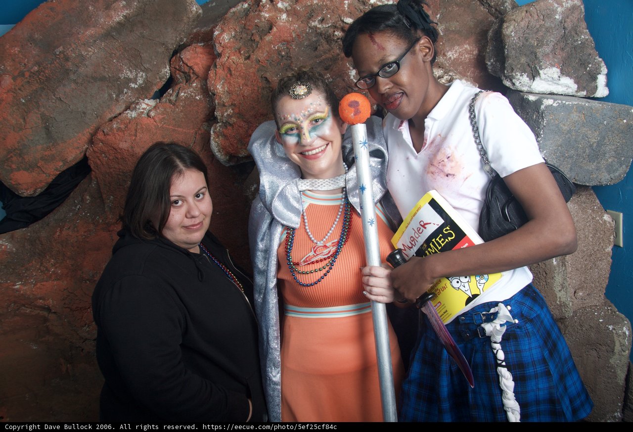 Three Women Strike a Pose with a Statue