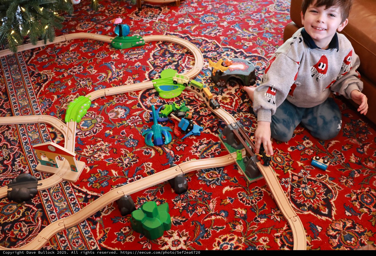 Young Boy Playing with Wooden Train Set on Christmas