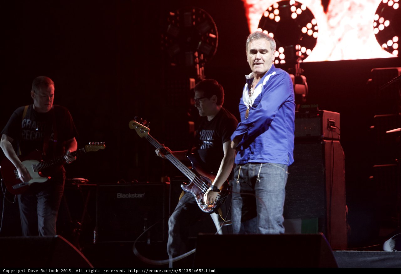 Morrissey Standing Blue Shirt Bassist Glasses Foreground Guitarist Capitol Tee Blackstar Circular Light