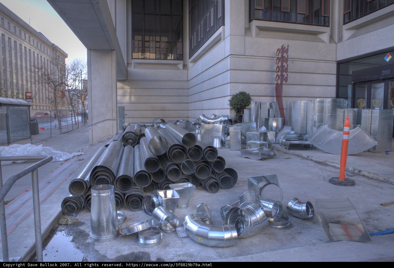 Pile of Metal Pipes on the Sidewalk