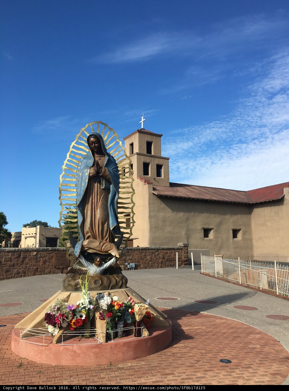 Statue of a Woman with Flowers and Church in Background