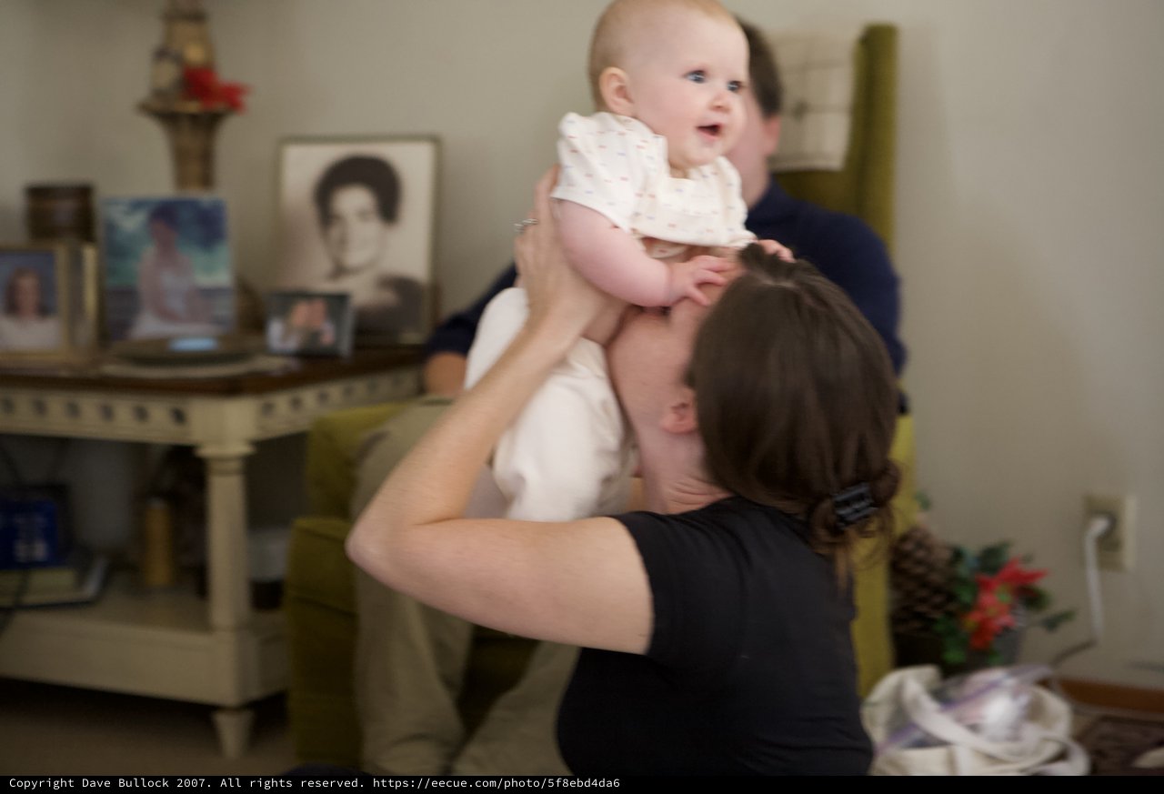 Joyful Mother Lifting Happy Baby in Living Room