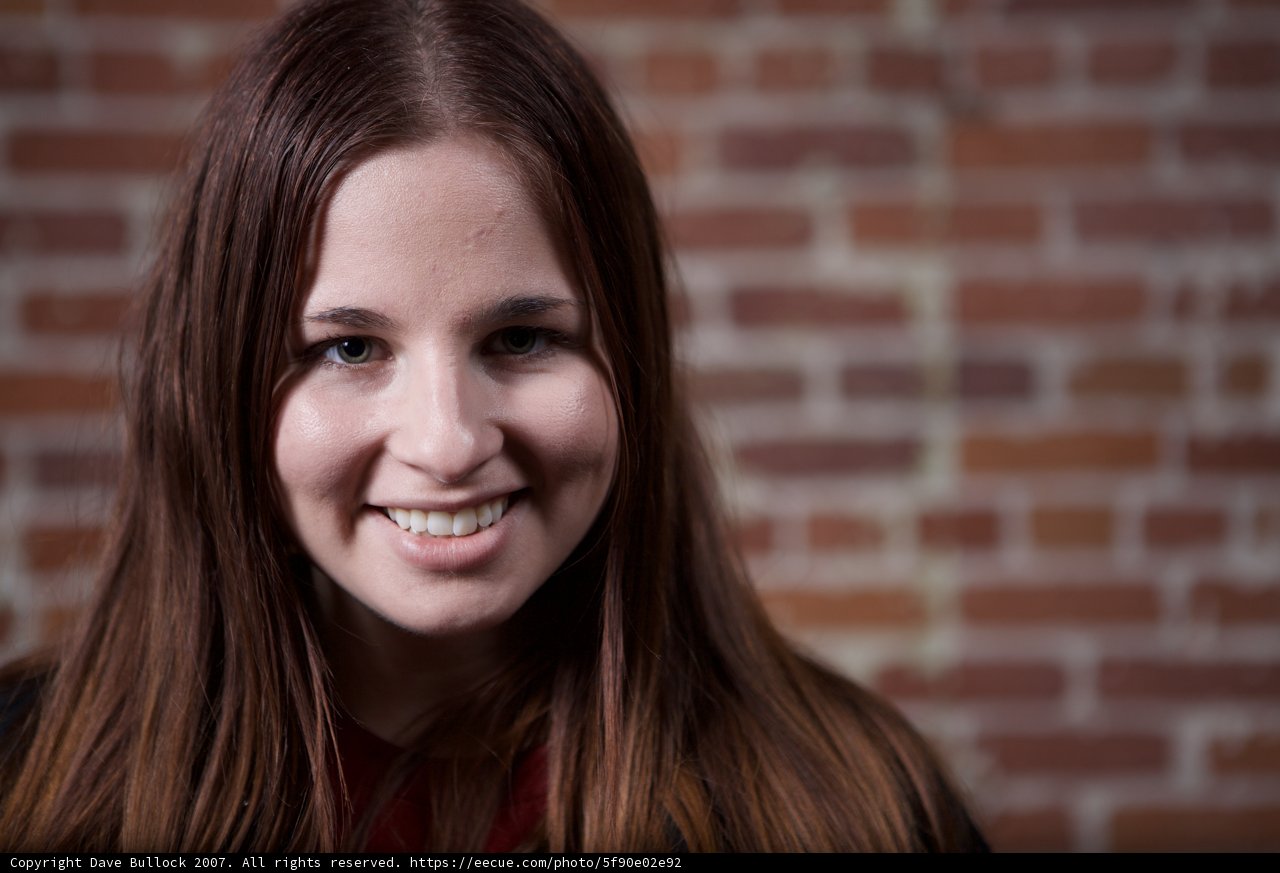 Happy Woman in front of a Brick Wall