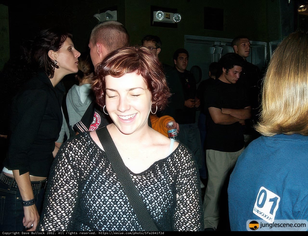 Smiling Woman Stands Out in Crowded Nightclub