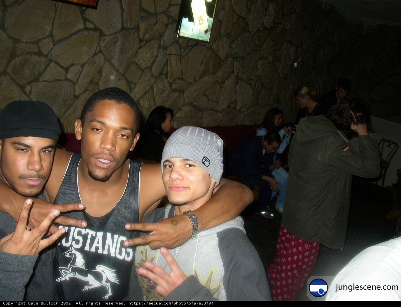 Three Young Men Strike a Pose at a Club Party