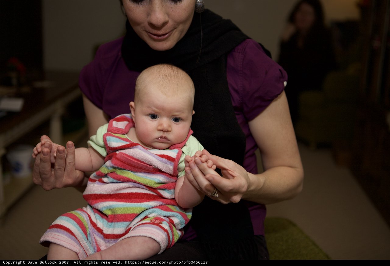 Mother Holding Alert Baby in Colorful Striped Outfit