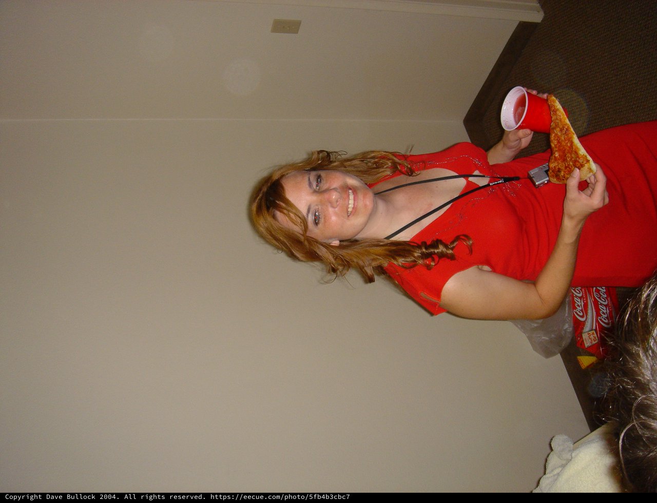 Young Woman Enjoys Pizza and Drinks at Party